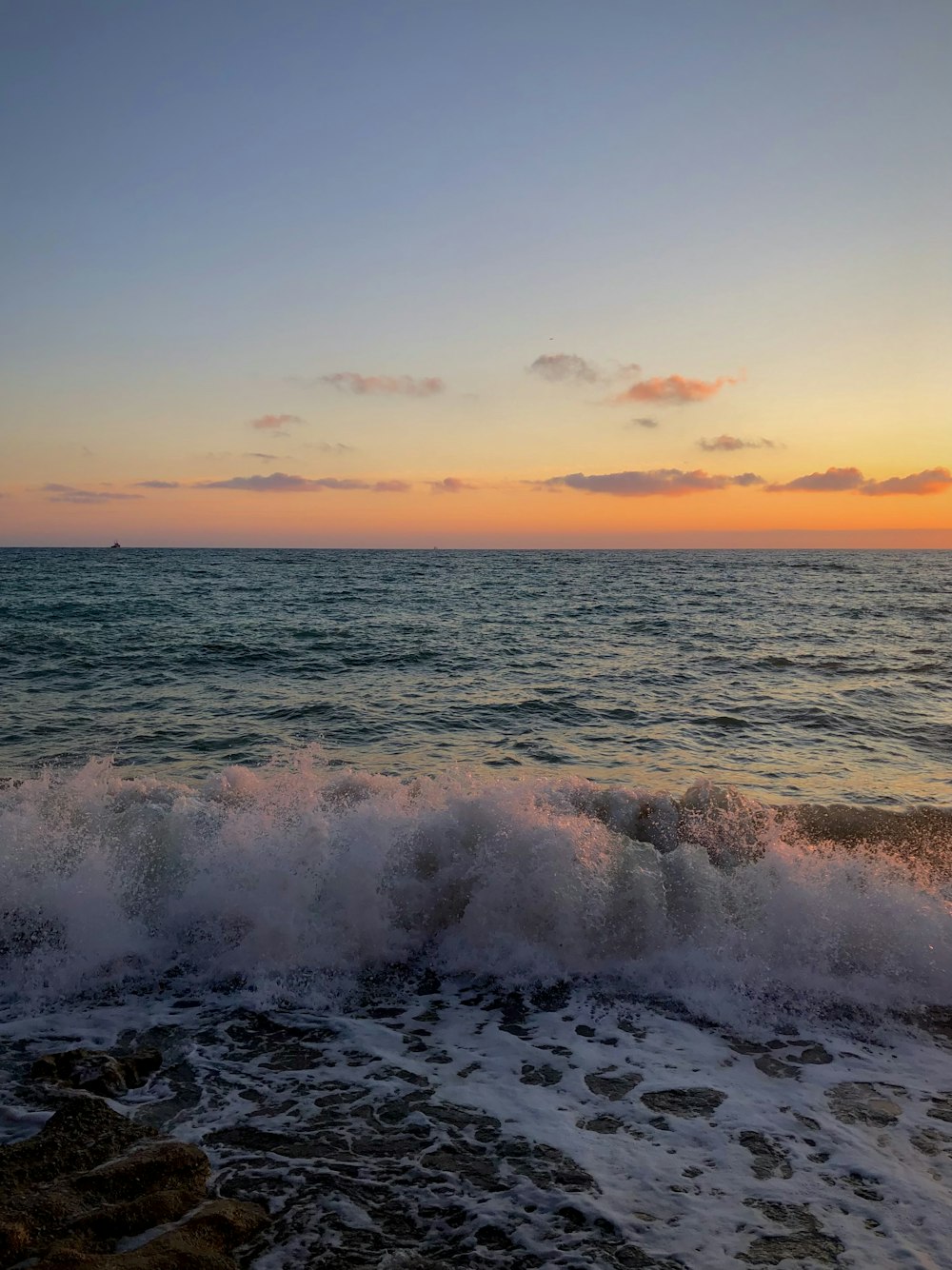 the sun is setting over the ocean with waves