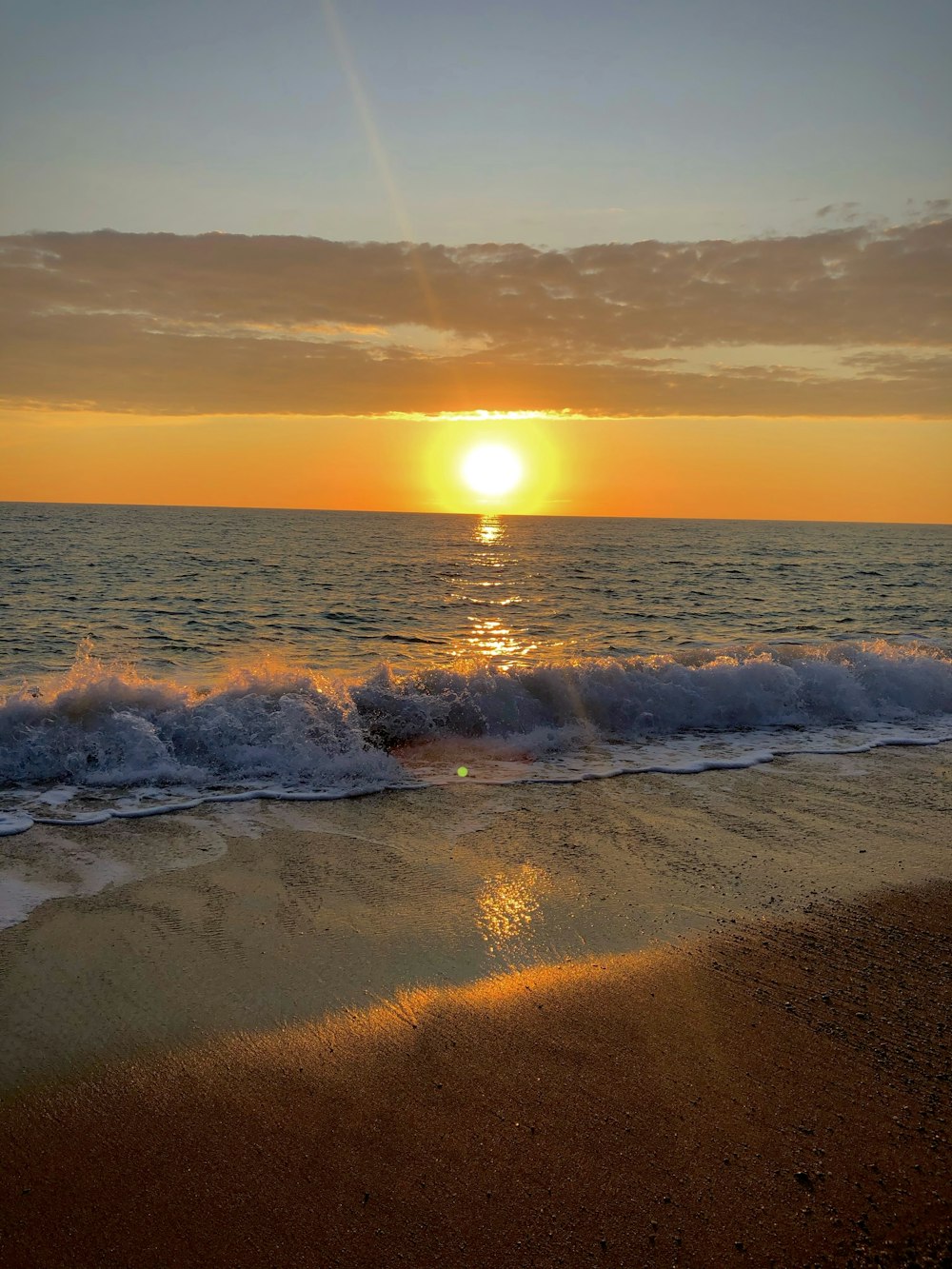 the sun is setting over the ocean waves