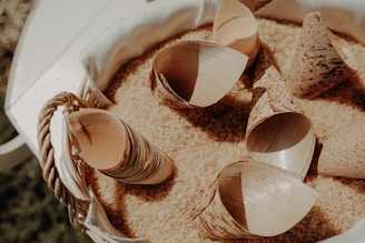 a bucket filled with sand and seashells on top of a table