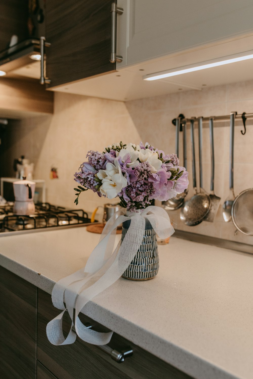 a vase of flowers sitting on a kitchen counter