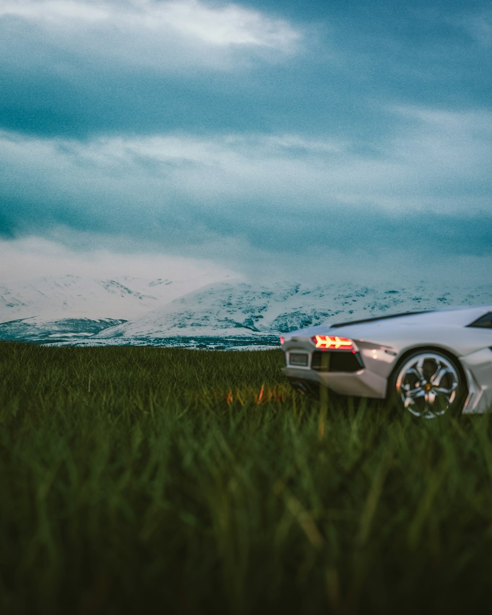 a white sports car parked in a grassy field