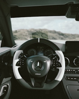 A close-up of a sleek car dashboard with African landscapes visible through the windshield.