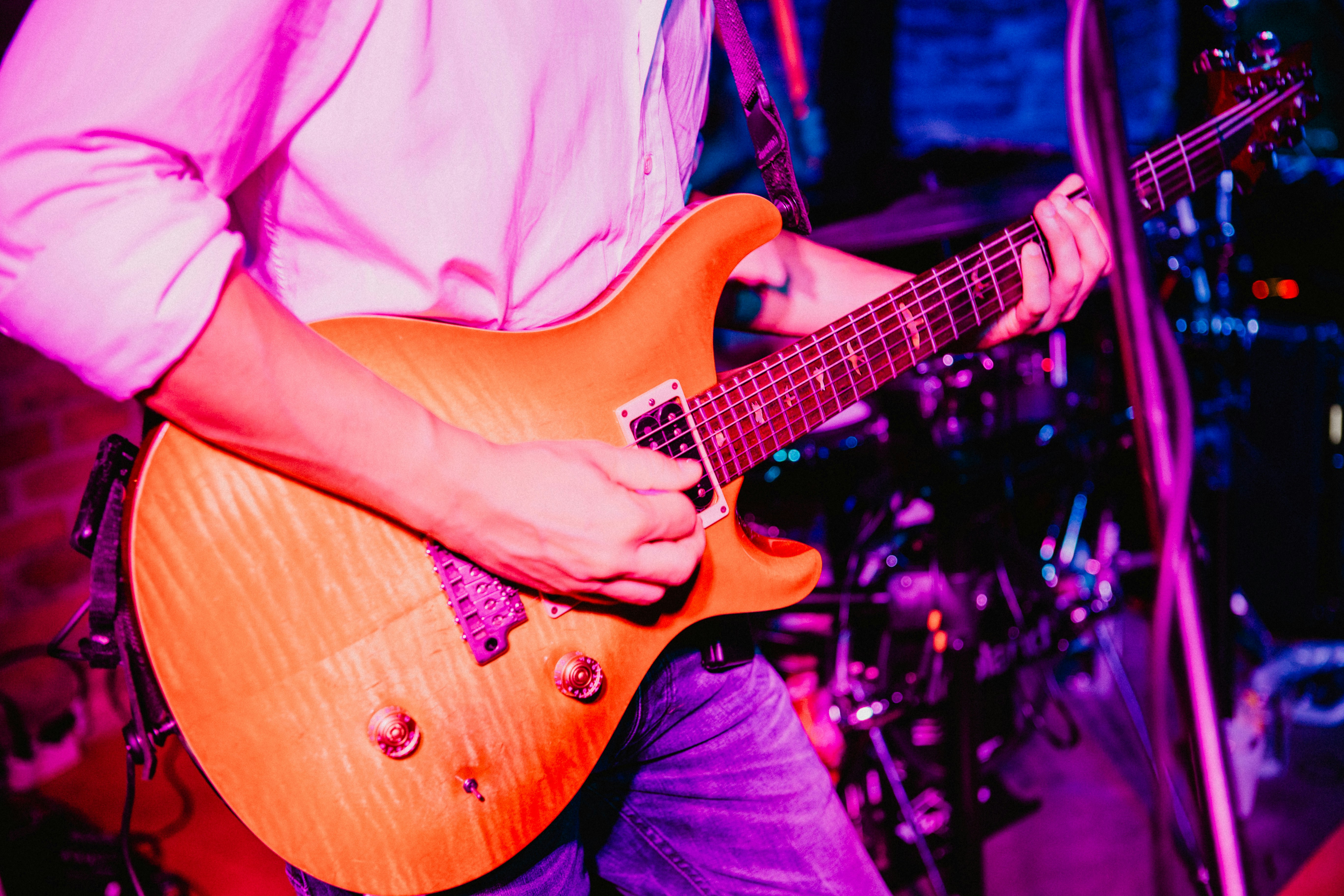 a man playing a guitar in front of a microphone