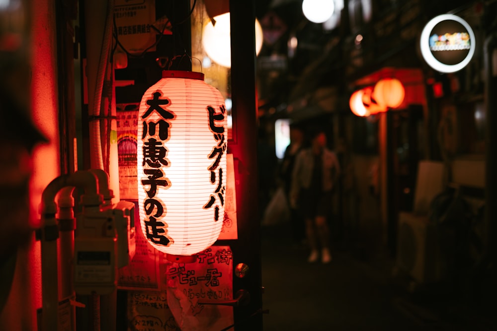 a lantern with asian writing on it is lit up at night