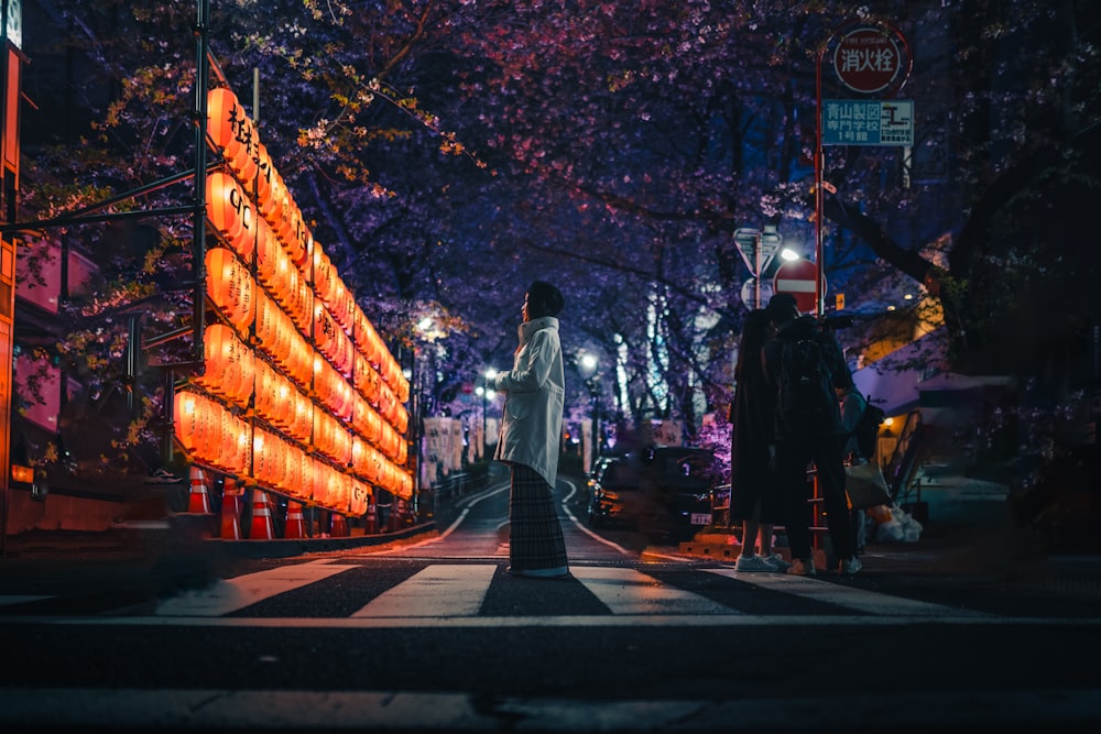 a woman walking down a street at night
