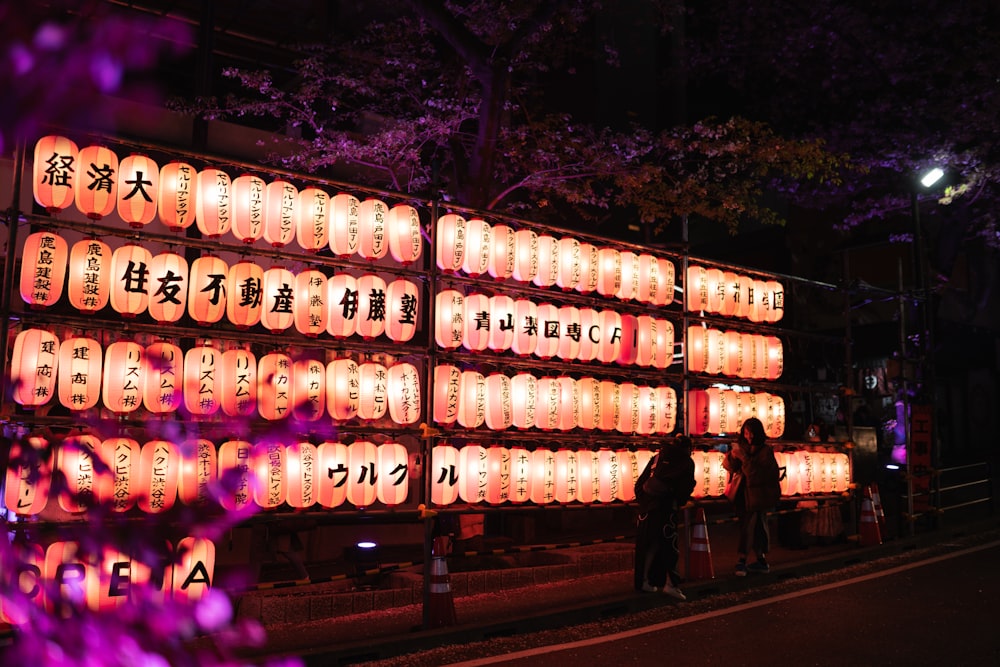 a large display of lit up lanterns on the side of a road