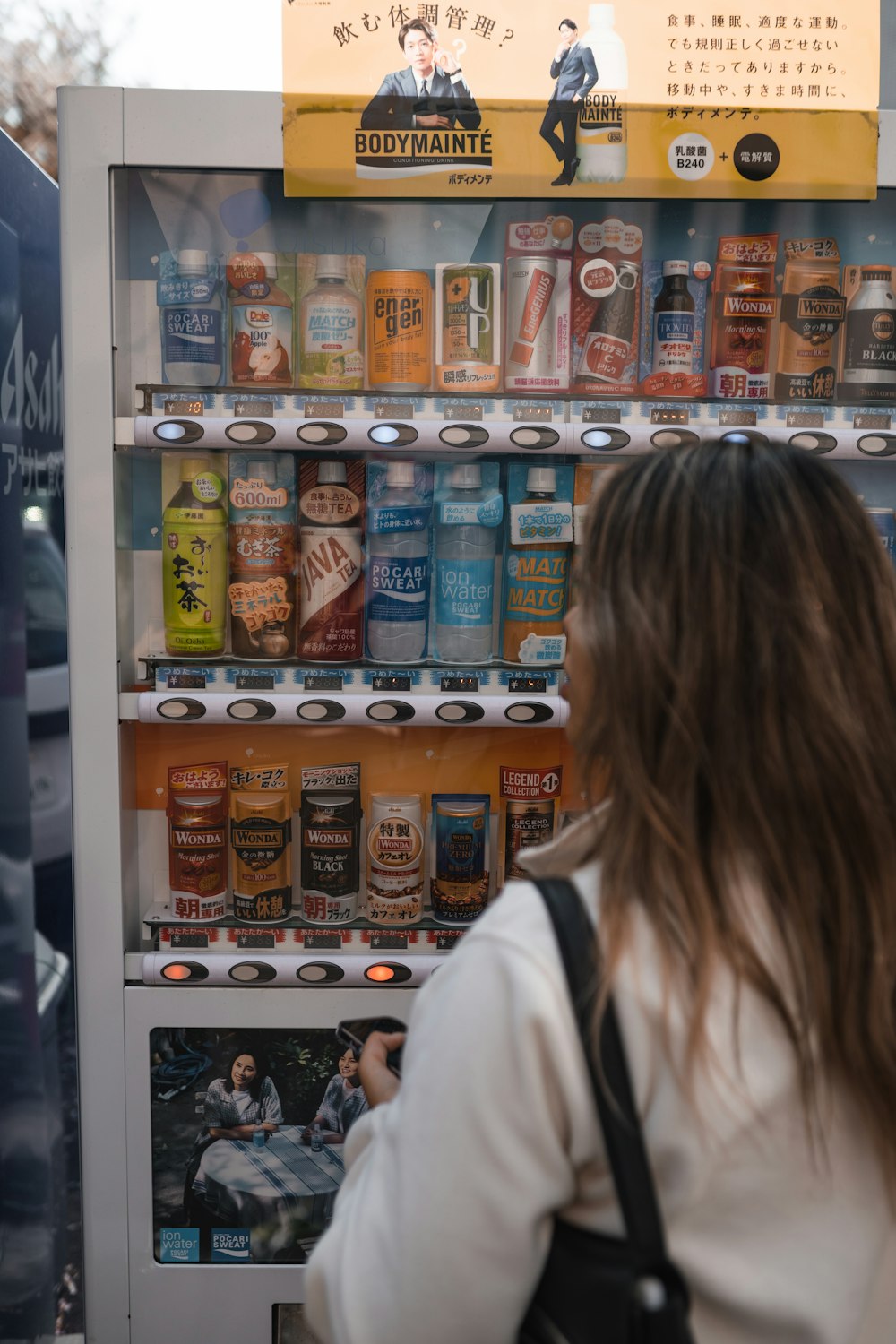 a woman standing in front of a vending machine