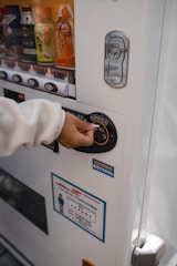 a person using a vending machine for drinks