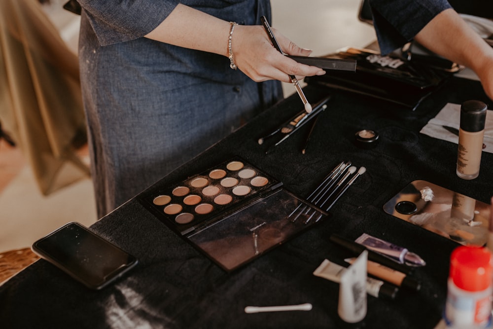 a woman is putting makeup on a table