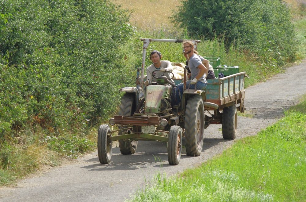 a couple of people riding on the back of a tractor