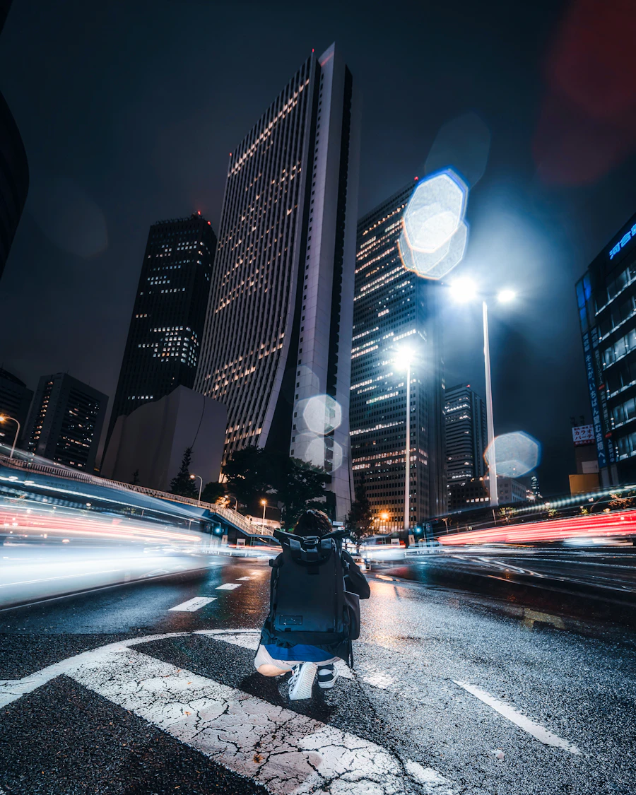A scooter rider among towers and light trails