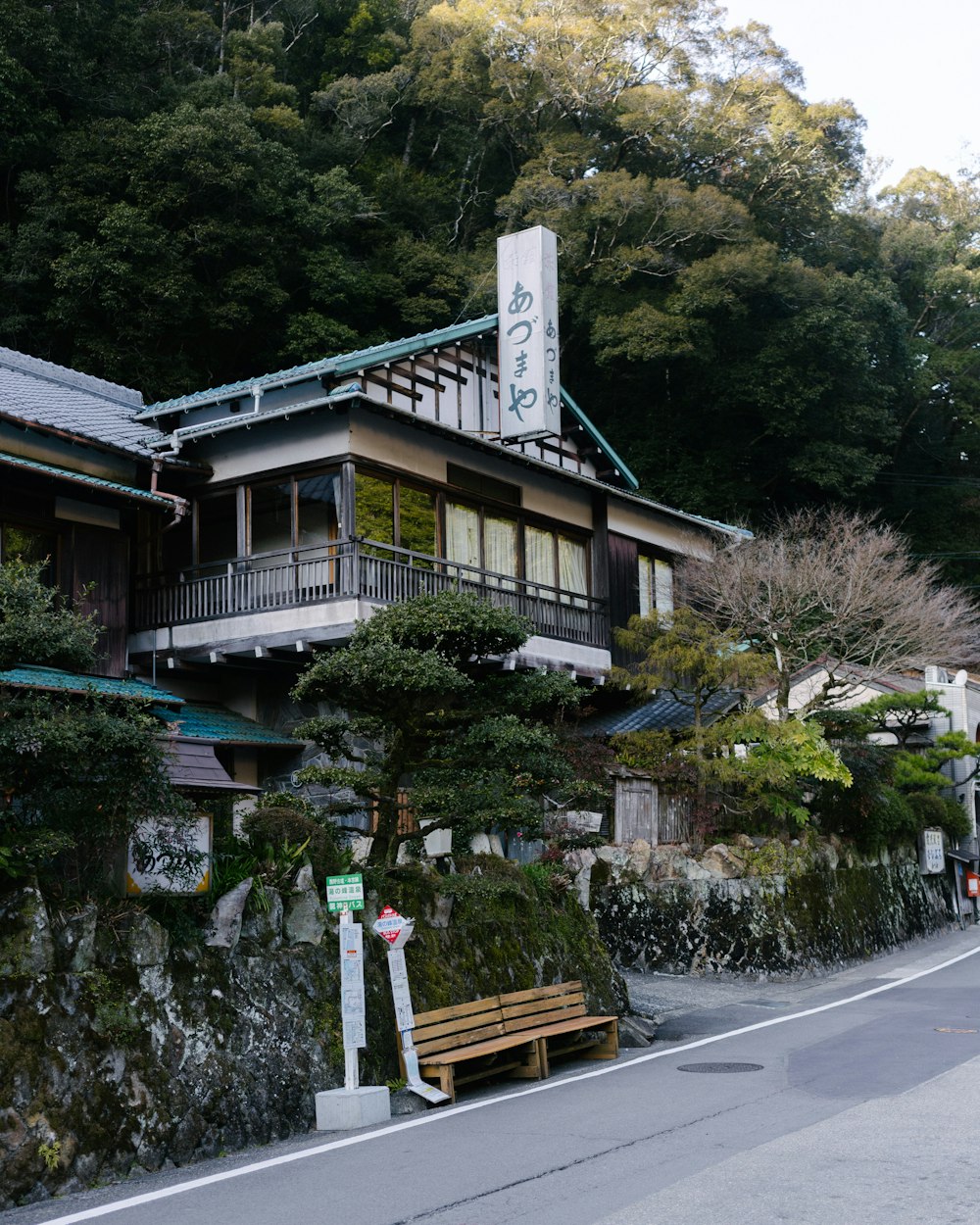 a building with a green roof and a wooden bench in front of it