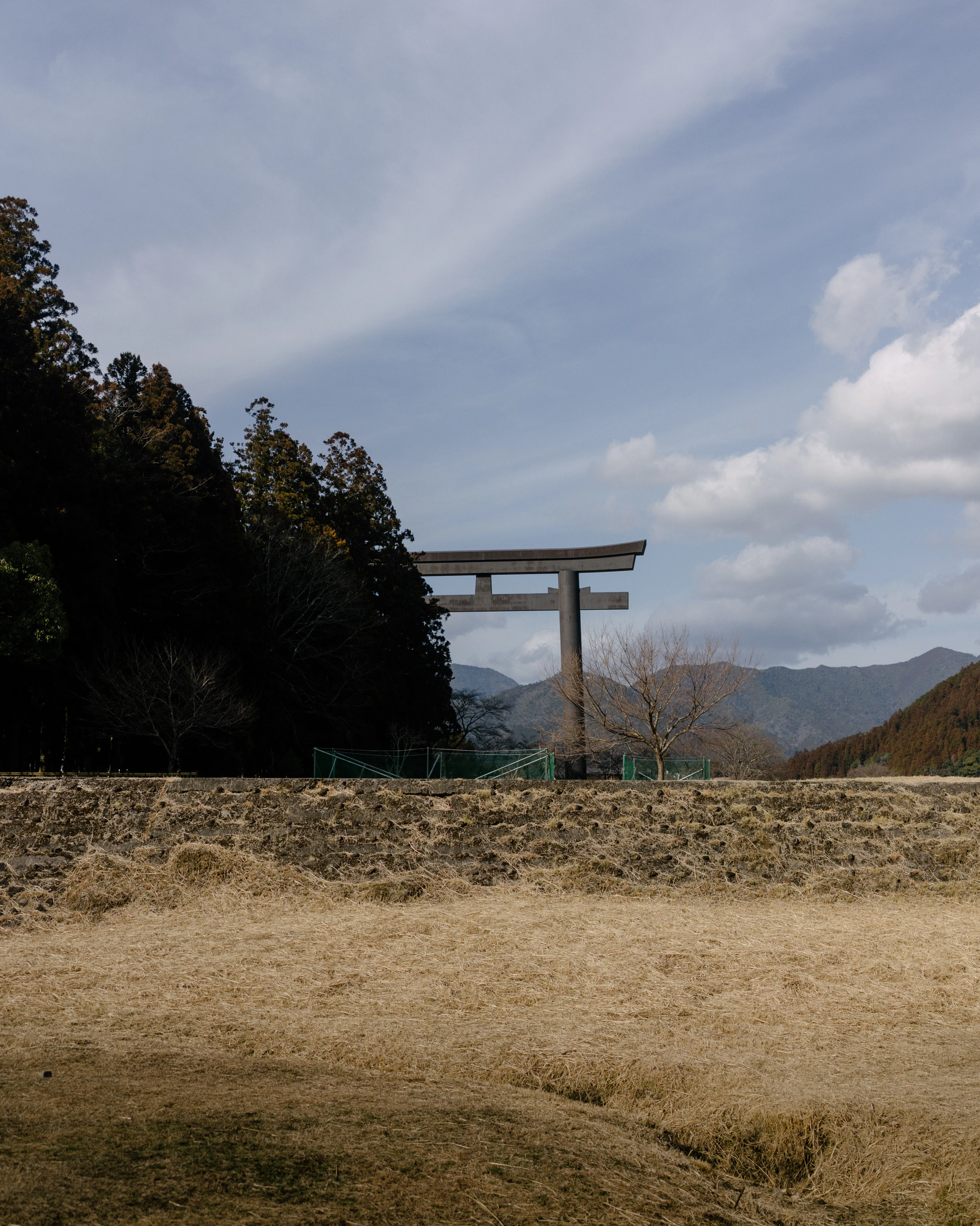 A vast torii gate rising above open fields in the Kii mountains