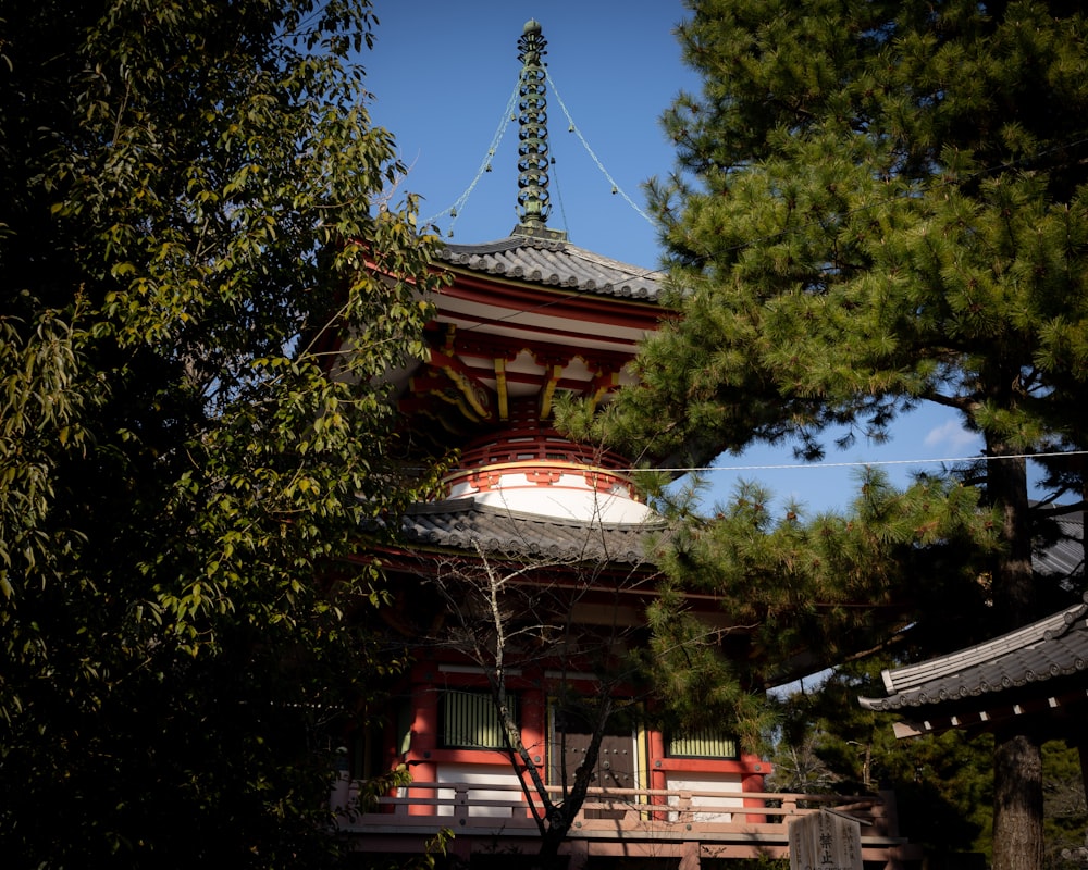 a tall red and white building surrounded by trees