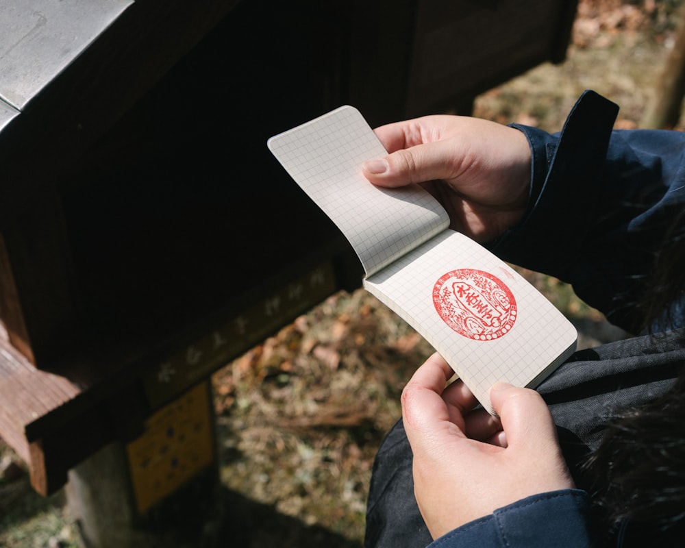 a person holding a piece of paper with a stamp on it