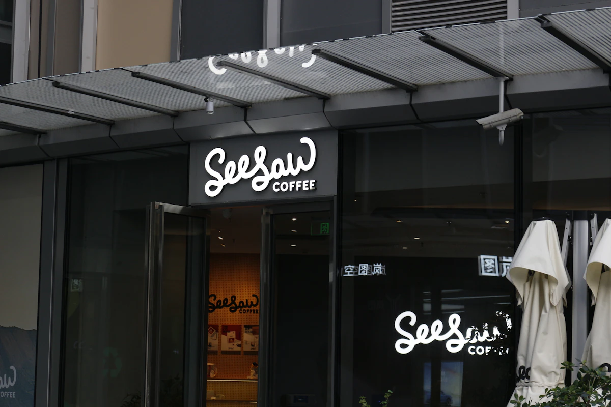 Coffee shop storefront at night with a clear, well-lit sign showing the business name