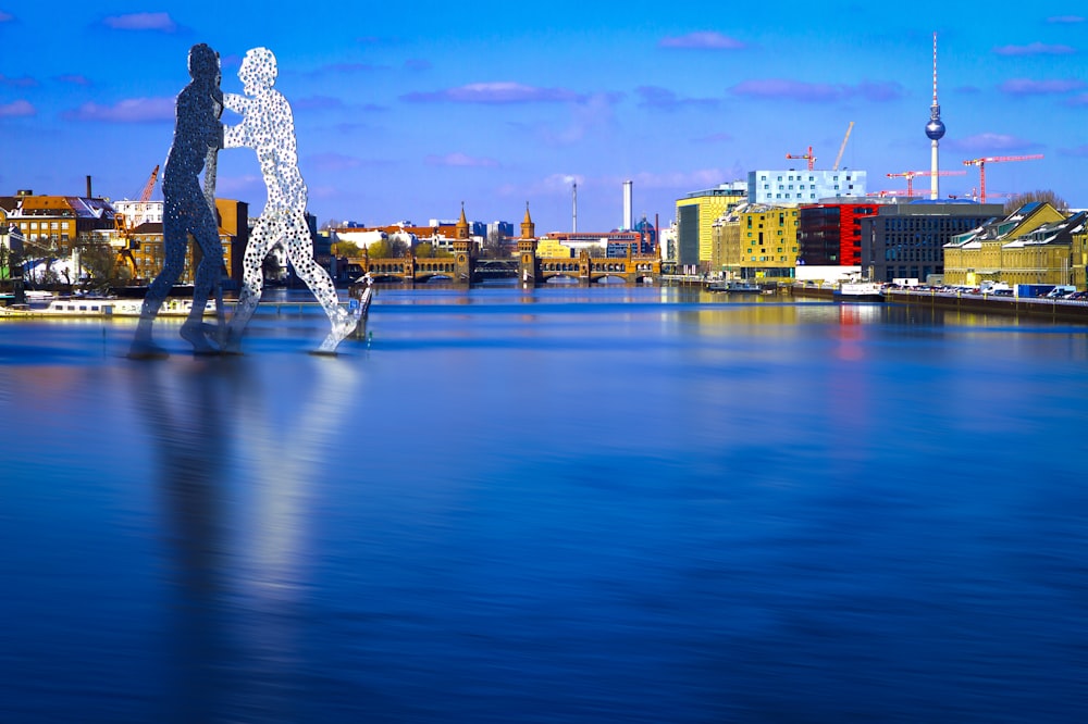 a body of water with a statue in the middle of it