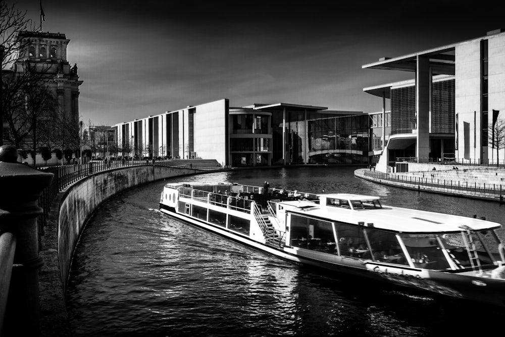 a boat traveling down a river next to a tall building