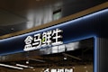 A store entrance with a prominent sign in Chinese characters, backlit by blue neon lights. The sign has a modern design with a clean and sleek appearance. Below the main sign, there is an additional English word 'Fruit', indicating the type of products available in the store.