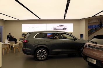 a couple of cars are parked in a showroom