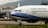 An airplane with the branding of China Airlines is positioned on an airport tarmac. The aircraft is a commercial passenger jet, featuring a white and blue color scheme with the registration number B-18658 visible. In the background, there is a building with signage for China Airlines, indicating an airport setting with mountainous terrain in the distance.