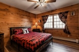 Comfortable guest room featuring plaid bedding and forest-themed decor.