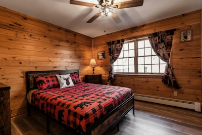Comfortable guest room featuring plaid bedding and forest-themed decor.