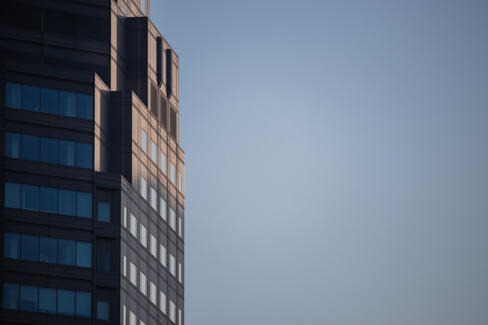 Un edificio alto con un aereo che vola nel cielo