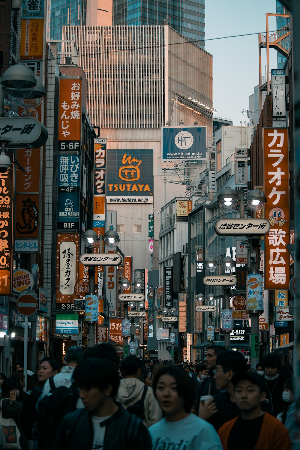 a group of people walking down a street next to tall buildings