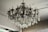 A luxurious, intricate chandelier is hanging from the ceiling, adorned with numerous crystal pendants and ornate metalwork. The chandelier features several bulb sockets shaped like candles, contributing to a classic and elegant appearance. The crystals catch and reflect light, adding a touch of sparkle.