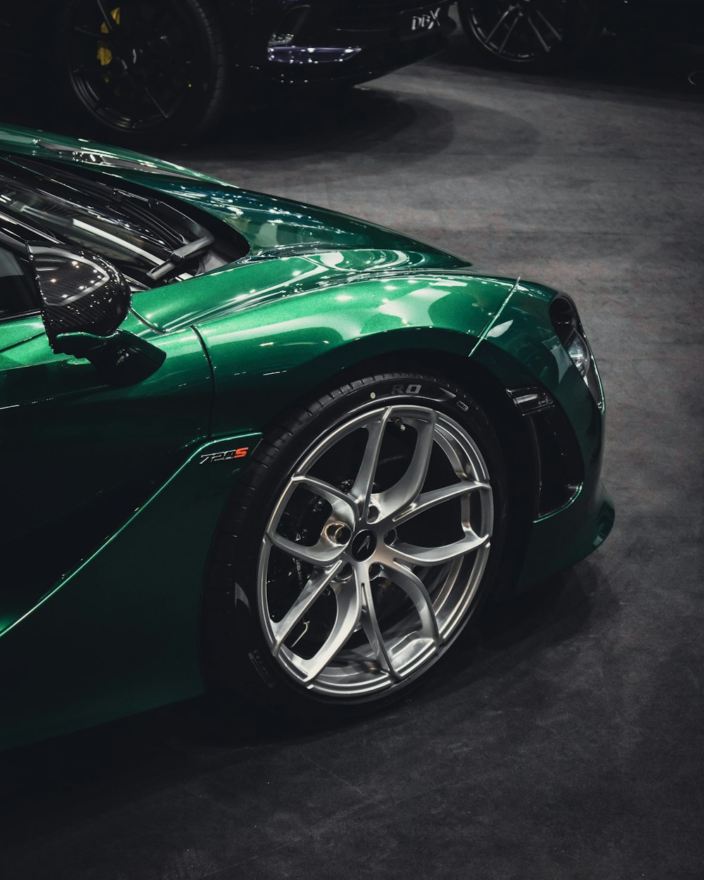 a green sports car parked in a showroom