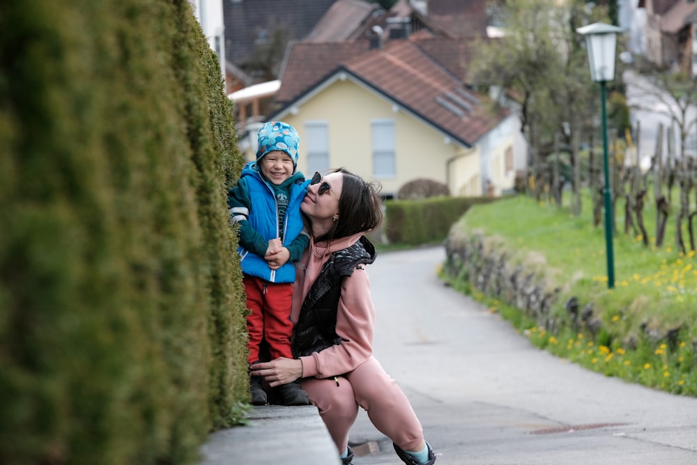 a woman kissing a child on the side of a road