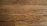 Wooden floor planks with visible grain and texture, featuring some scratches and imperfections.