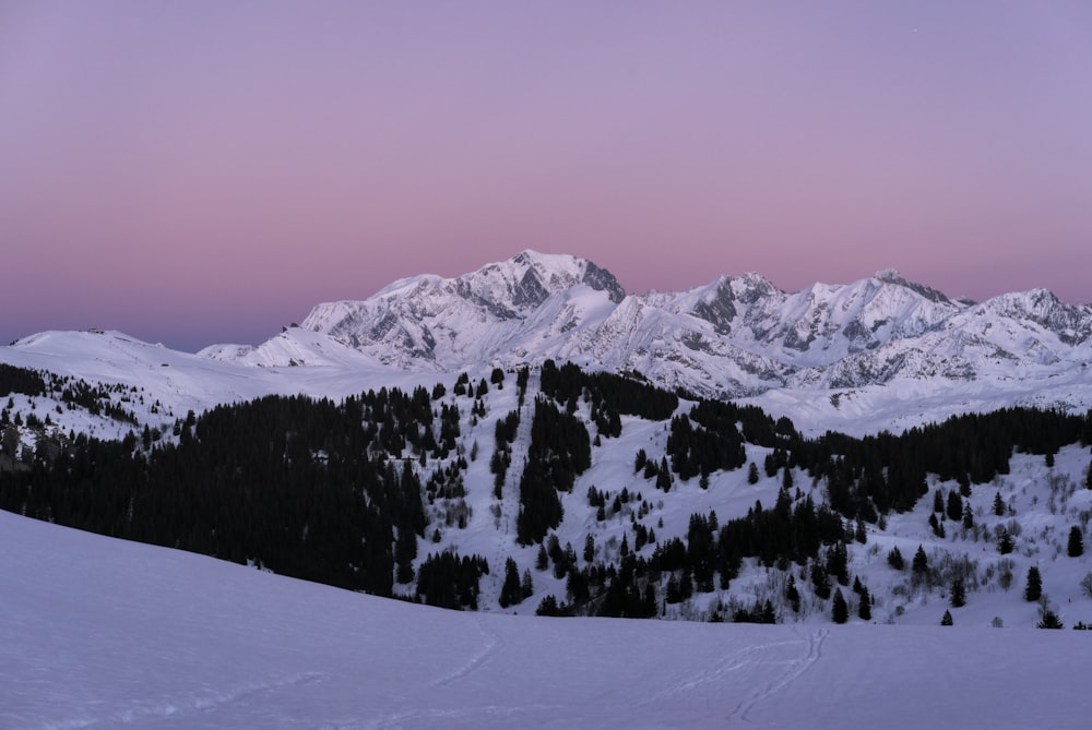 a snow covered mountain with a pink sky in the background