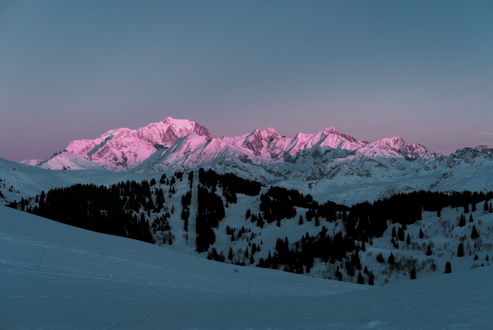 a snow covered mountain with a pink sky in the background