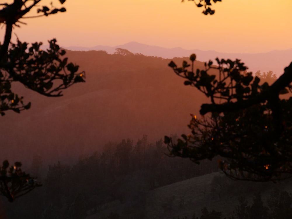 the sun is setting over a mountain range