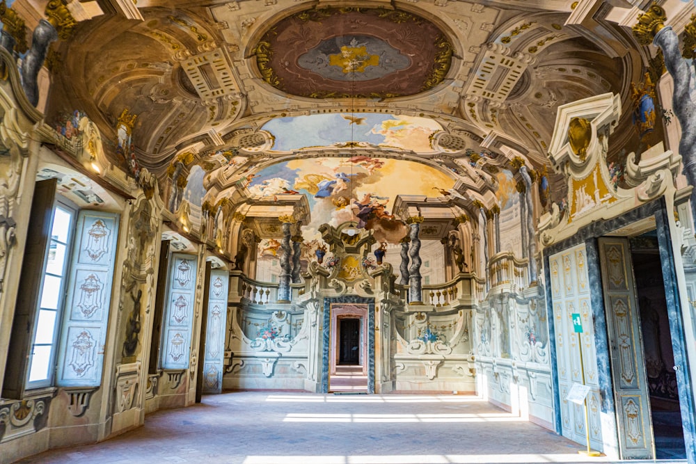 a large room with a ceiling painted in gold and white