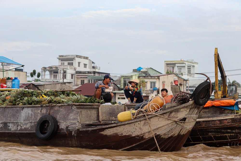 a group of people sitting on top of a wooden boat