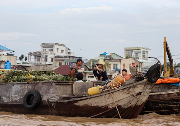 a group of people sitting on top of a wooden boat