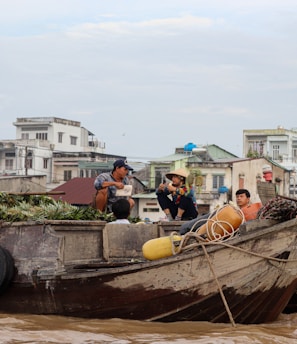 a group of people sitting on top of a wooden boat