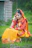 a woman sitting in the grass talking on a cell phone