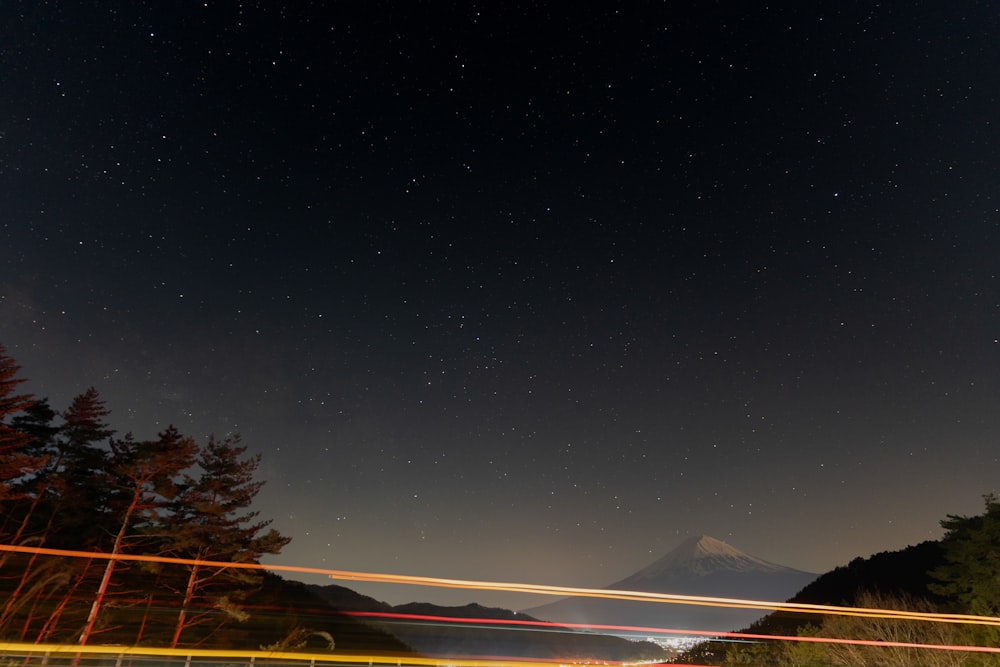 a night sky with a mountain in the background