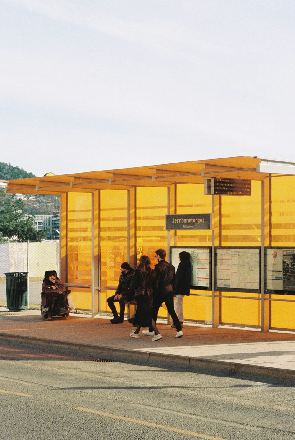 a group of people standing next to a bus stop