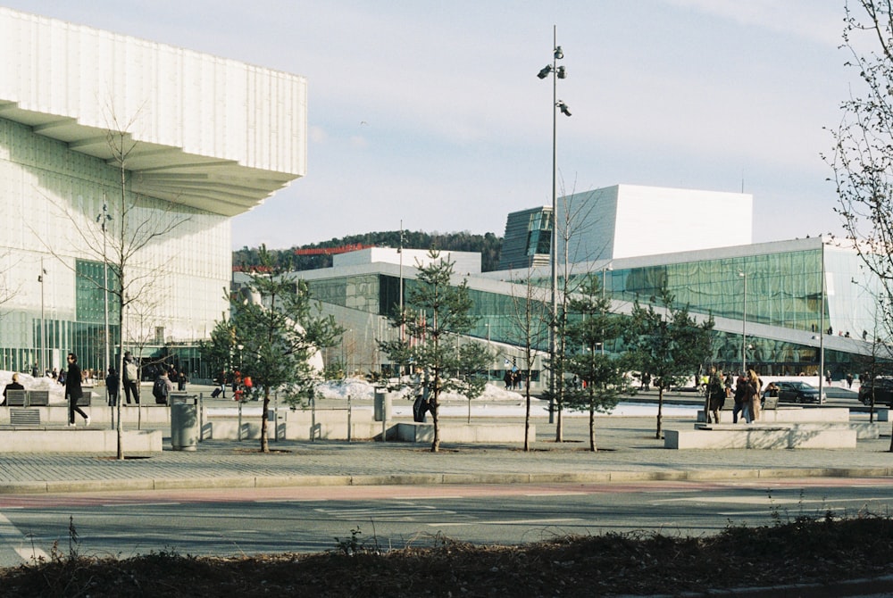 a group of people walking on a sidewalk next to a building