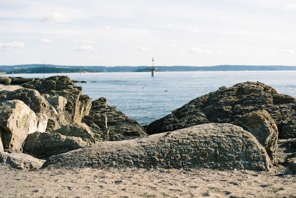 rocks on a beach with a body of water in the background