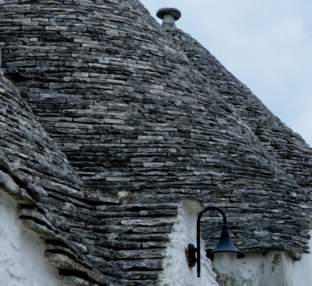 a stone building with a light on the side of it