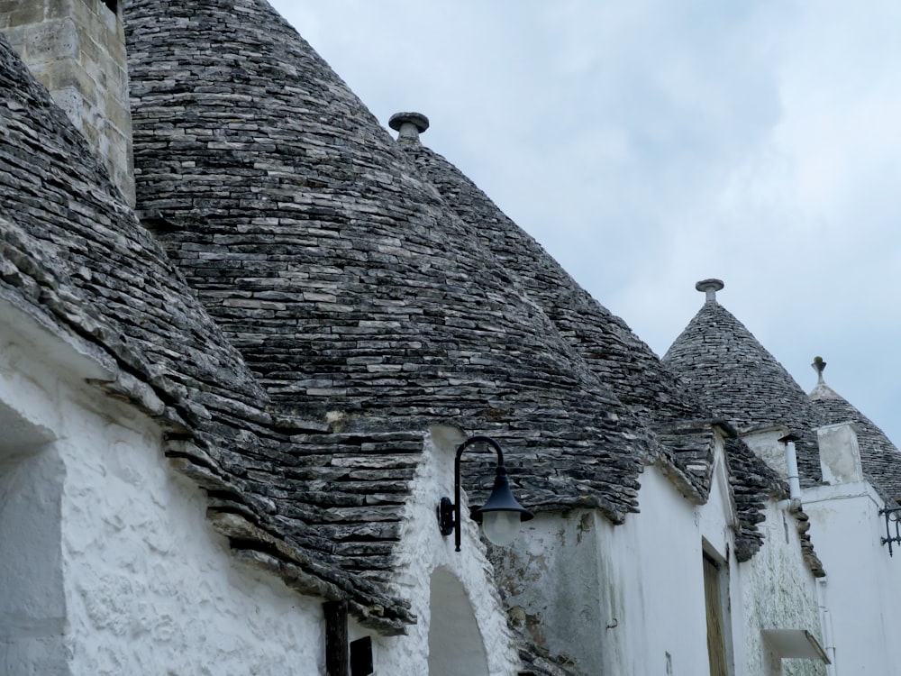 a row of white buildings with stone roofs
