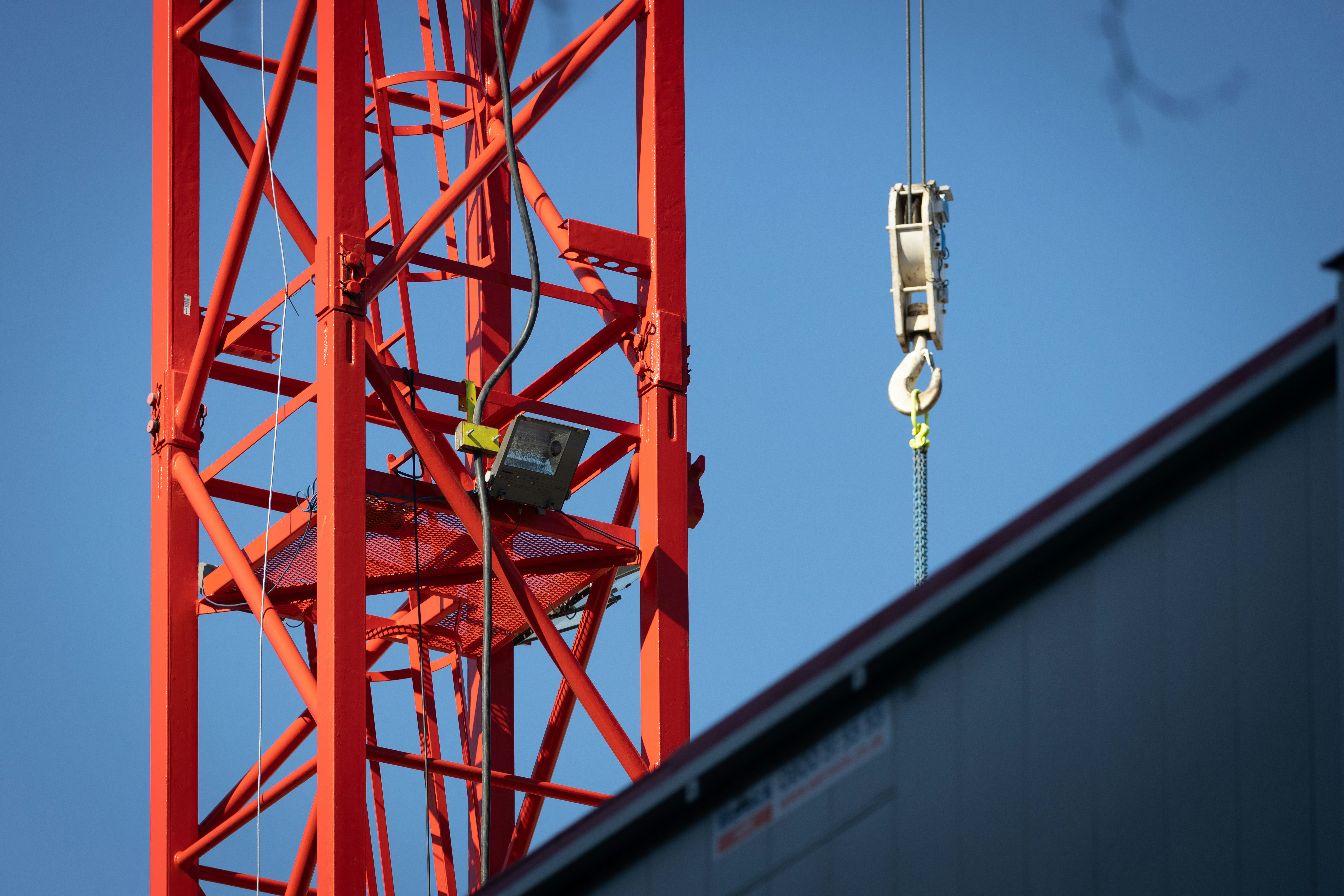 A red tower crane stands out against blue spring skies above central London