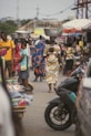 a woman walking down a street with a bucket on her head