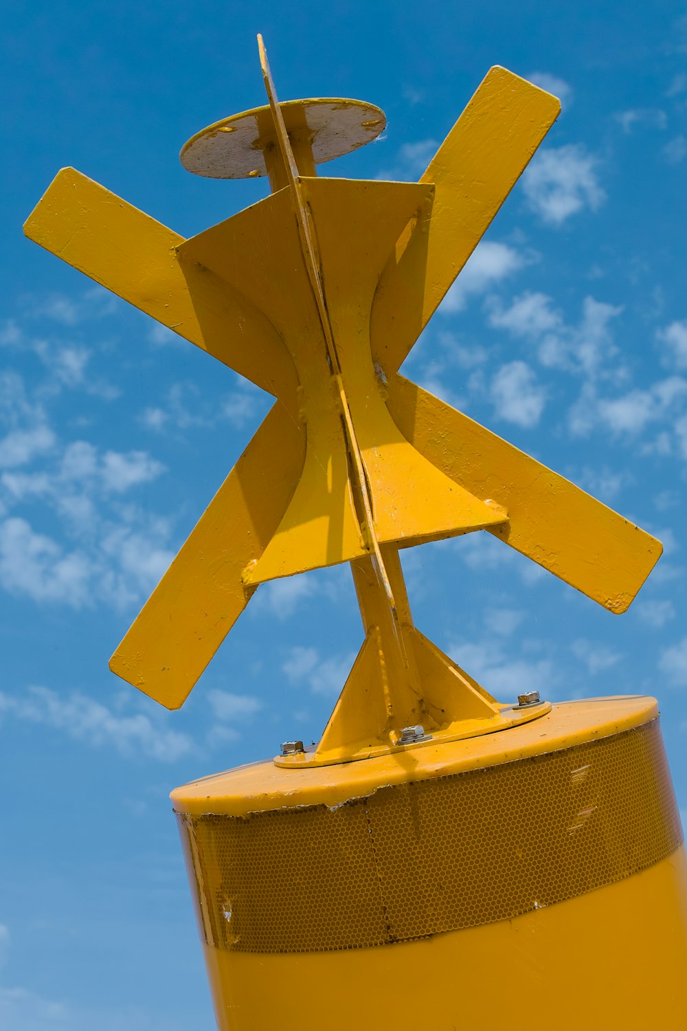 Un primer plano de un poste amarillo con un cielo azul en el fondo